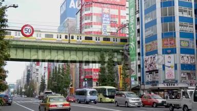 东京市中心一条繁忙的大街上，一座铁路桥下的交通经过. 地铁火车从繁忙的道路上经过，高高地起